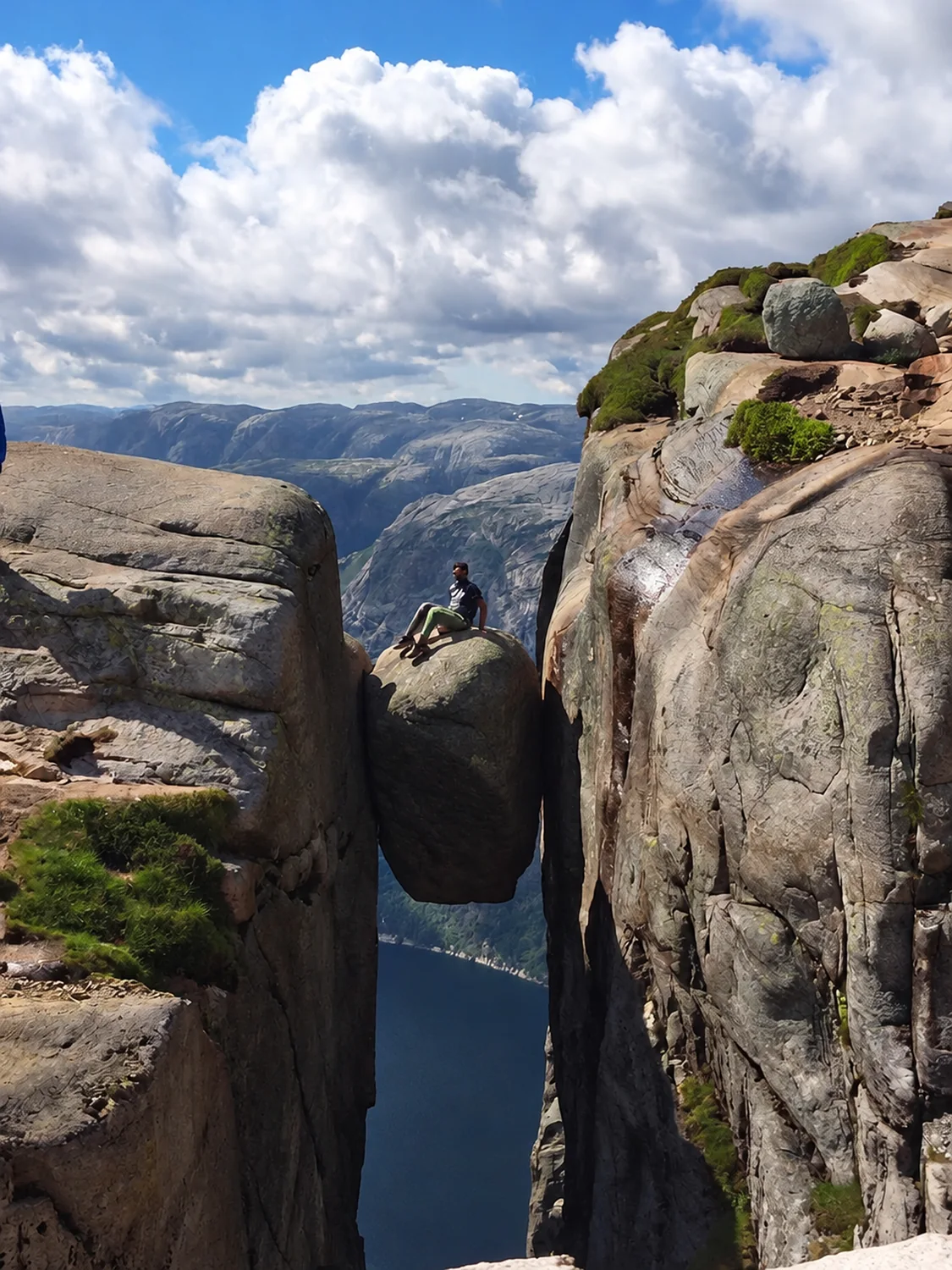 Kjeragbolten, a boulder wedged between two cliffs above a deep fjord in Norway